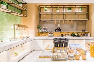 a kitchen with a person standing in the background at Atour Hotel (Nanjing Xingang Development Area) in Nanjing