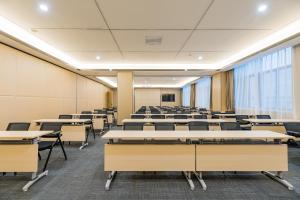 an empty lecture room with tables and chairs at Atour Hotel (Nanjing Xingang Development Area) in Nanjing