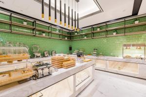 a large kitchen with green walls and a counter top at Atour Hotel (Nanjing Xingang Development Area) in Nanjing
