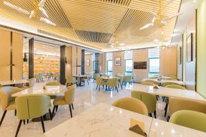 a dining room with tables and chairs at Atour Hotel (Nanjing Xingang Development Area) in Nanjing