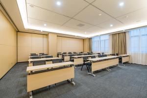 an empty classroom with desks and chairs in a room at Atour Hotel (Nanjing Xingang Development Area) in Nanjing