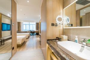 a hotel bathroom with a bed and a sink and a tub at Atour Hotel (Nanjing Xingang Development Area) in Nanjing