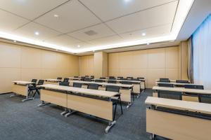 an empty classroom with rows of desks and chairs at Atour Hotel (Nanjing Xingang Development Area) in Nanjing