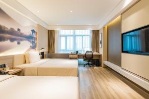 a hotel room with two beds and a flat screen tv at Atour Hotel (Nanjing Xingang Development Area) in Nanjing