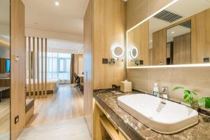 a bathroom with a sink and a large mirror at Atour Hotel (Nanjing Xingang Development Area) in Nanjing