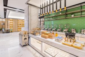 a bakery with a counter with food on it at Atour Hotel (Nanjing Xingang Development Area) in Nanjing