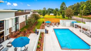 an overhead view of a pool at a hotel with blue umbrellas at Best Western Plus Yadkin Valley Inn & Suites in Jonesville