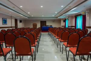 an empty room with red chairs and a podium at Kallada Hotels and Resorts in Trichūr