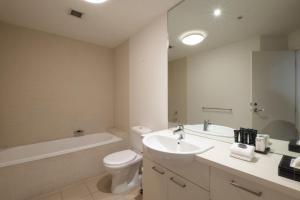 a bathroom with a sink and a toilet and a bath tub at ACD Apartments in Melbourne