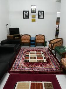 ein Wohnzimmer mit einem Sofa und einem Teppich in der Unterkunft TSA Jitra Homestay in Kampong Pantai Halban