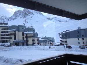 uma vista para uma montanha coberta de neve a partir de um edifício em Prariond 5 em Tignes