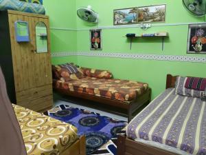 a room with two beds and a couch in it at TSA Jitra Homestay in Kampong Pantai Halban