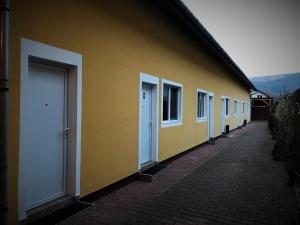 a row of white doors on a yellow building at Petőfi Motel in Cristuru Secuiesc