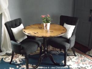 a table with two chairs and a potted plant on it at Maison Porte del Marty in Lalinde