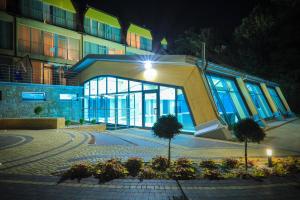 a large building with a lit up entrance at night at Hotel *** NAT Ustroń in Ustroń