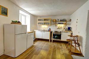 a kitchen with white appliances and a wooden floor at Ferienhaus Ehrenpreis in Wißmannsdorf