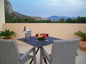 una mesa con un bol de frutas y copas de vino en Miraluna Aparthotel, en Lefkos Karpathou