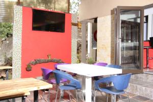 patio ze stołem i krzesłami oraz telewizorem w obiekcie View Inn Exclusive Lodge w mieście Nelspruit