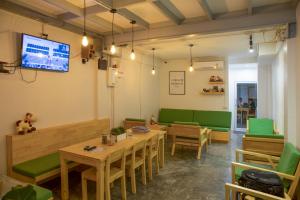 um restaurante com mesas de madeira e cadeiras verdes em Ekanake hostel em Bangkok