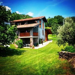 a house with a green lawn in front of it at Casa Vacanze La CASA DEL SOLE in Angolo Terme