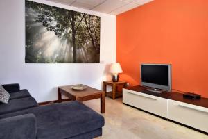 een woonkamer met een bank en een flatscreen-tv bij City Living Suite TK 2 Rm 3. in St Julian's