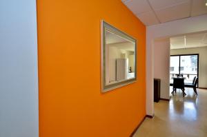 una pared naranja en una oficina con espejo en City Living Suite TK 2 Rm 3. en San Julián
