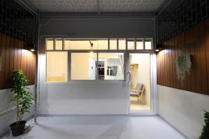 een kamer met een glazen deur met een stoel erin bij Ekanake hostel in Bangkok