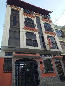 un edificio con ventanas de barrotes negros y una puerta en Hostal Intiwatana Inn, en Puno