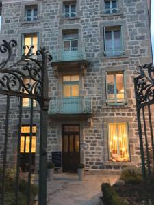 a large stone building with windows and a balcony at La Maison de famille in Boën