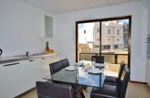 una sala da pranzo con tavolo in vetro e sedie di City Living Suites TK2 Rm 2 a San Giuliano