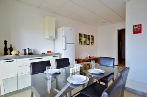 una sala da pranzo con tavolo in vetro e sedie di City Living Suites TK2 Rm 2 a San Giuliano