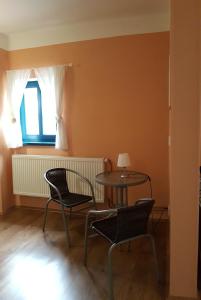 een kamer met een tafel en stoelen en een raam bij Apartment Jakubske Namesti in Česká Kamenice