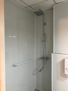 a shower with a glass door in a bathroom at Hôtel le Rohu in Séné