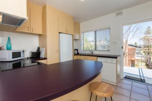 a kitchen with a large black counter top at Cottesloe Marine Apartment in Perth