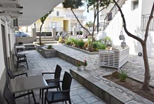 an outdoor patio with tables and chairs and a table at Vicky Studios in Myrina