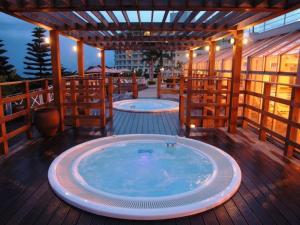 duas banheiras de hidromassagem no convés de um edifício em Okinawa Kariyushi Beach Resort Ocean Spa em Onna