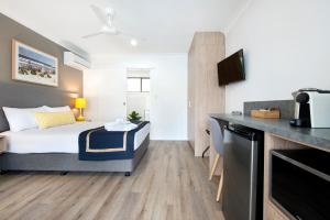 a hotel room with a bed and a kitchen at Blue Heron Boutique Motel in Gold Coast