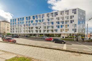 una strada con auto parcheggiate di fronte a un grande edificio di Center Apartment 10A a Vilnius