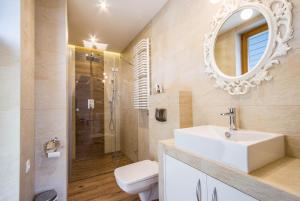 uma casa de banho com um lavatório, um WC e um espelho. em Apartamenty Smrekowa Lux Zakopane em Zakopane
