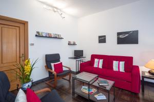 ein Wohnzimmer mit einem roten Sofa und einem Tisch in der Unterkunft Il Giardino delle Ortensie in Salto