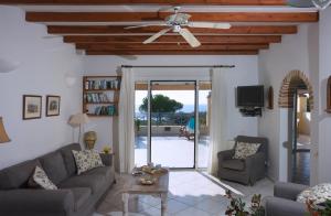 a living room with a couch and a ceiling fan at Panorama Villas in Arillas