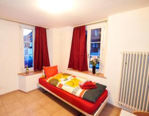 a bedroom with a bed and two windows at Sunny Day Holiday Apartment in Unterseen