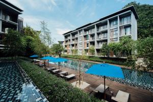 an image of a hotel with a pool and umbrellas at 23 Degree Condominium R76 in Phayayen