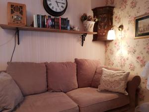 un sofá en una sala de estar con un reloj en la pared en Renkitupa en Raahe