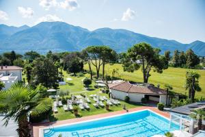an aerial view of a resort with a pool and mountains at Parkhotel Delta, Wellbeing Resort in Ascona