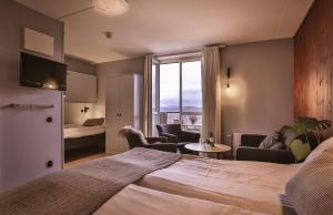 een hotelkamer met een bed en een woonkamer bij Bergshotellet in Järvsö