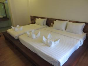 two beds with white pillows with white napkins at QUEEN'S HOUSE in Luang Prabang