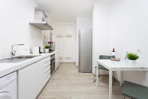 a white kitchen with a sink and a refrigerator at Monkey house in Santa Cruz de Tenerife