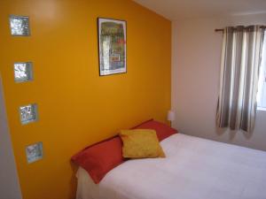 een slaapkamer met een bed en een gele muur bij Gîte de Preuilly in Auxerre