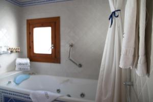 a white bathroom with a tub and a window at Hotel Abaco Altea in Altea